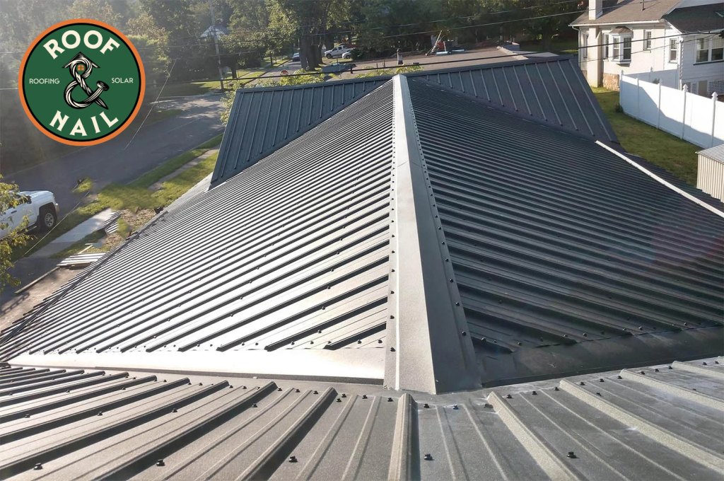 Overlapping corrugated roofing panels with a durable ridge cap