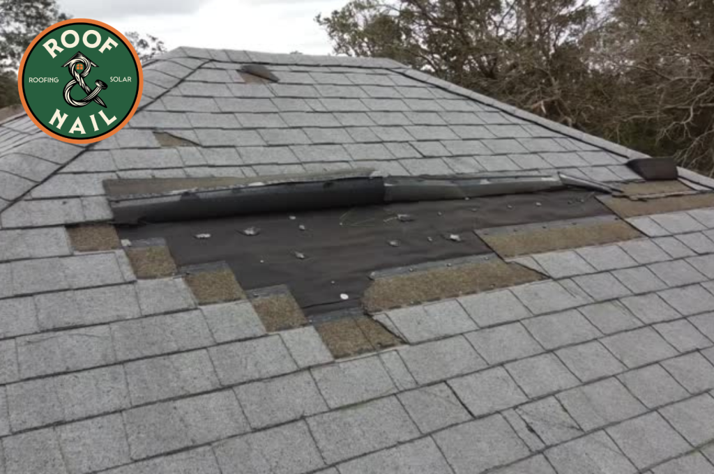 Missing asphalt shingles exposing the roof deck and underlayment